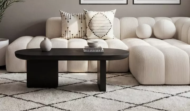 Produktfoto: cremefarbenes Sofa mit schwarzem ovalem Couchtisch